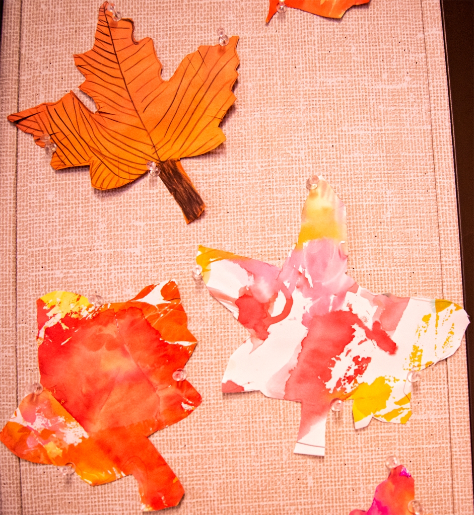 Kindergarten students' autumn leaves, made with warm colored bleeding tissue paper