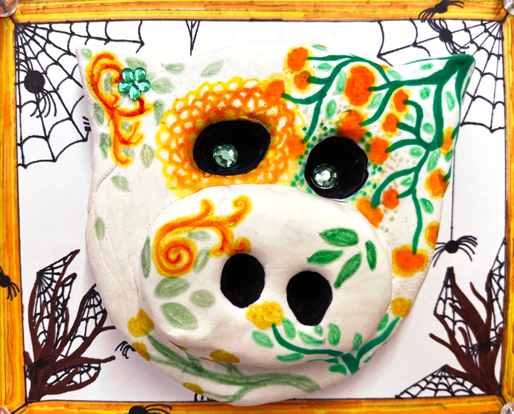 4th grade calaveras- Dia de los Muertos "sugar" skulls made out of model magic clay and decorated in multicolors of markers and sharpies, as well as plastic "gems", and placed on a decorative background in various designs and patterns, also made by the students